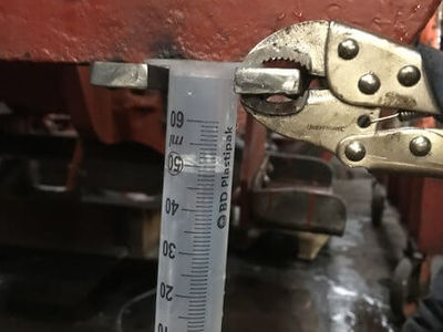A close up of the water gauges. All four corners are connected with hose and the water level appears on the scale. When all four corners of the loco are level, the water reads the same on each gauge.